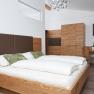 Modern bedroom with wooden furniture, double bed, table and chairs.