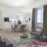 Modern living room with kitchen, dining table and stylish furniture.