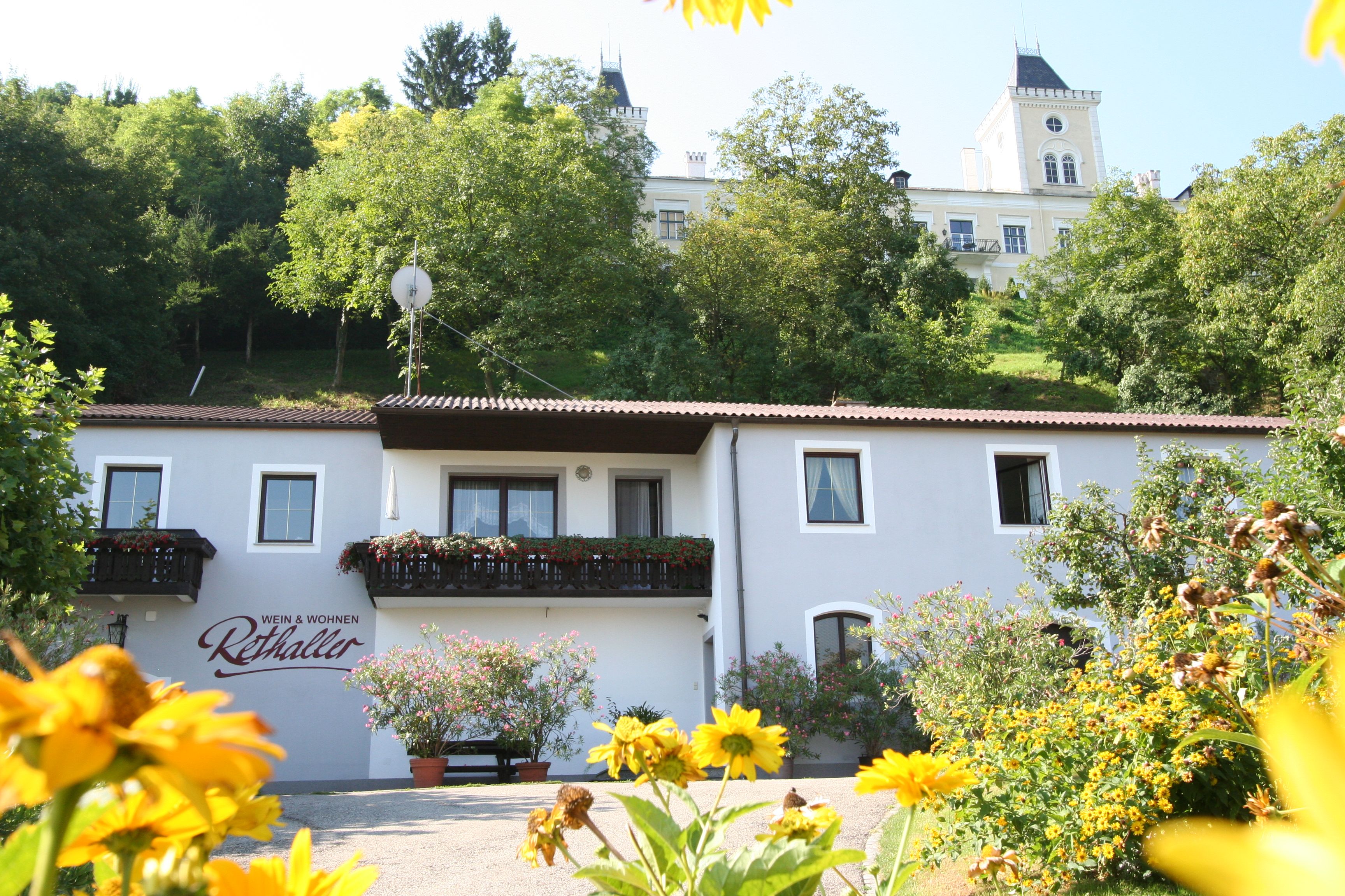 Außenansicht eines Hauses mit Blumen und einem Gebäude im Hintergrund.