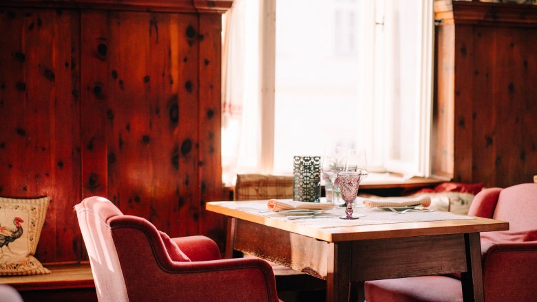 Gem&uuml;tliche Einrichtung mit Holzw&auml;nden und roten Sesseln.