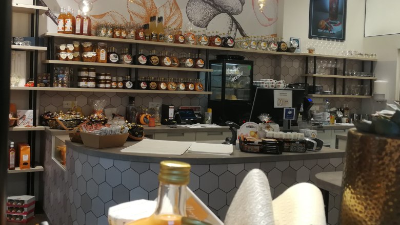 Innenansicht eines Ladens mit Regalen voller Likörflaschen und Marmeladengläser.